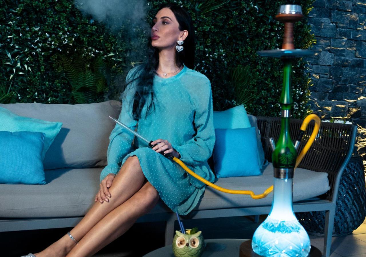 Moevenpick Hotel & Apartments Bur Dubaj Kültér fotó A woman smoking a hookah